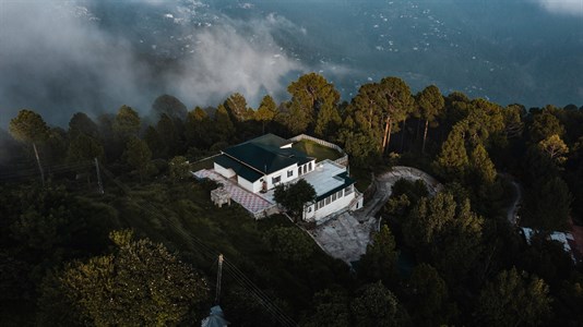 White and blue house on top of green mountains