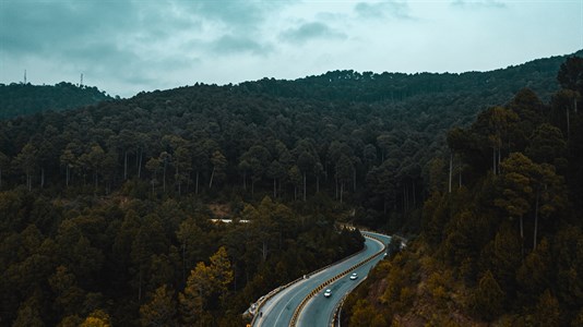 Aerial view of road in the middle of green mountains