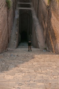 Man standing on the stairs leading towards the well in Rohtas Fort