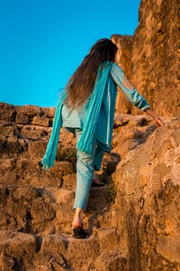 Girl in Pakistani dress climbing the stairs of ancient Rohtas Fort