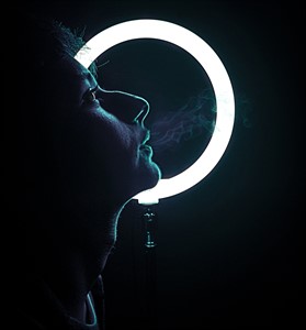 Boy smoking in front of light