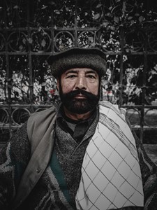 A portrait of a man wearing a traditional Pashtun cap