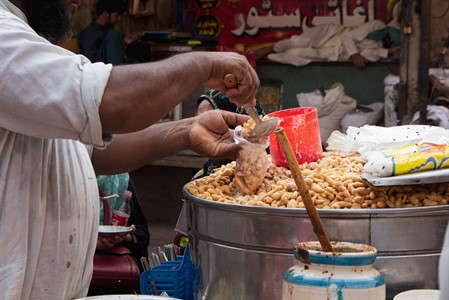 Vendor pouring Dahi Bhallas