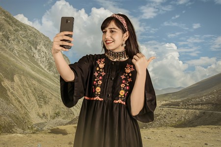 North girl using mobile in traditional dress