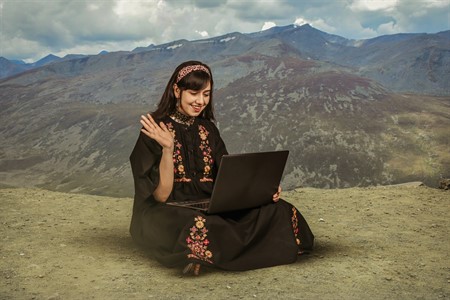 Girl in traditional clothes using laptop