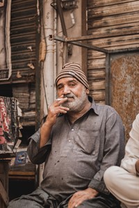 old man in street smoking cigarette