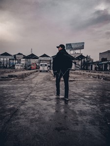 Boy alone standing at the bus station 